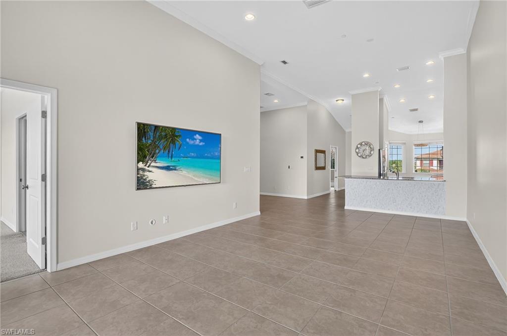 9386 Pocida Court, Unit 202 Naples, FL 34119 - Photo 19 of 38 Unfurnished living room featuring crown molding, tile patterned floors, and recessed lighting