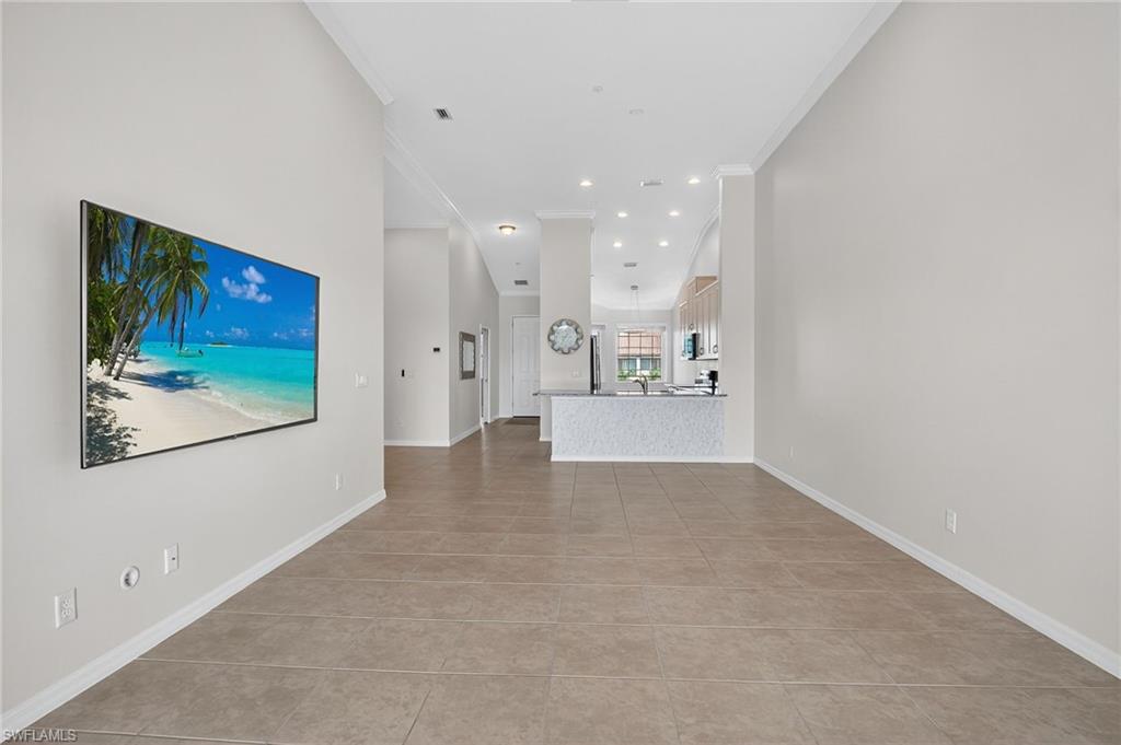 9386 Pocida Court, Unit 202 Naples, FL 34119 - Photo 20 of 38 Unfurnished living room with ornamental molding, light tile patterned floors, and recessed lighting