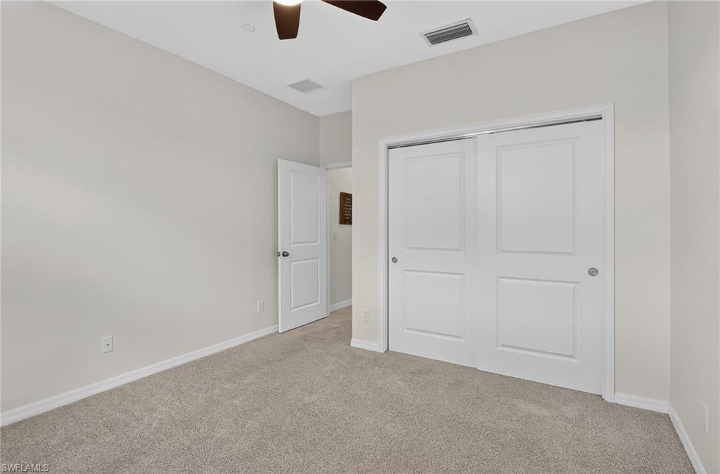 9386 Pocida Court, Unit 202 Naples, FL 34119 - Photo 22 of 38 Unfurnished bedroom with light colored carpet, a closet, and a ceiling fan