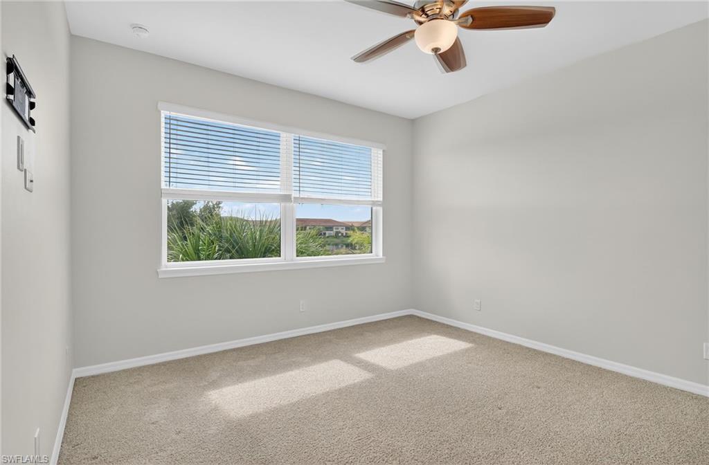 9386 Pocida Court, Unit 202 Naples, FL 34119 - Photo 26 of 38 Carpeted empty room with baseboards and a ceiling fan