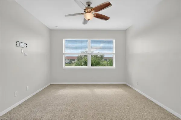 a view of an empty room with a chandelier fan