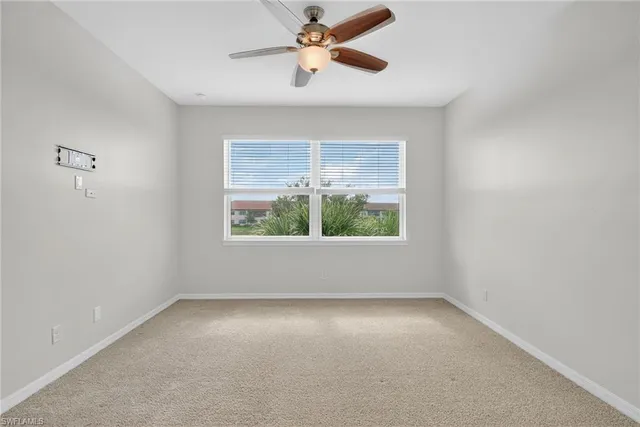a view of an empty room with a chandelier fan