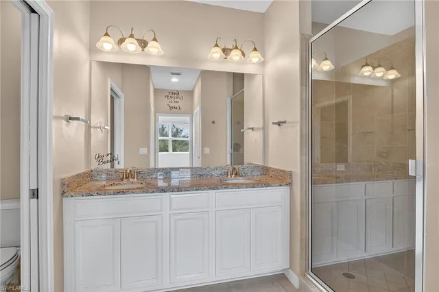 a bathroom with a granite countertop sink a mirror and a shower