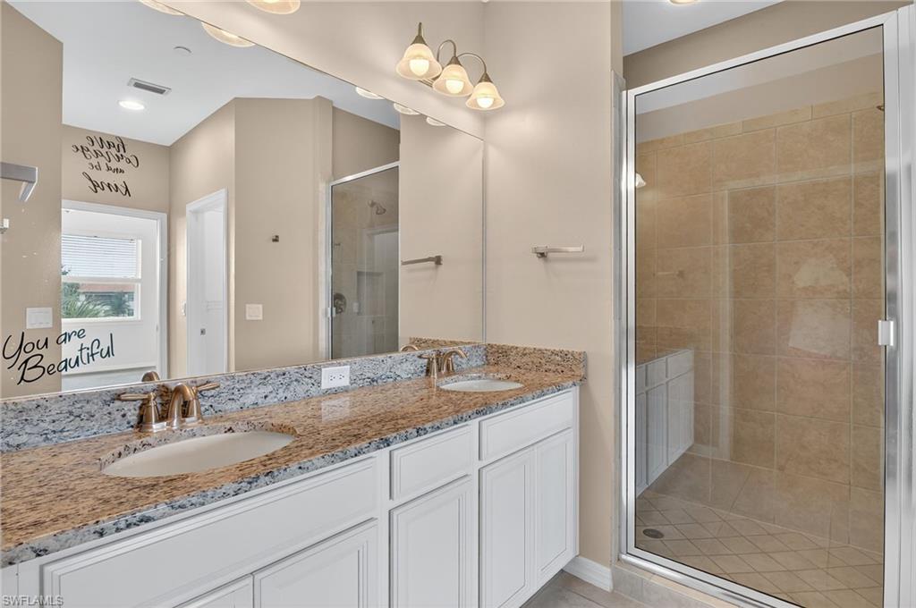 9386 Pocida Court, Unit 202 Naples, FL 34119 - Photo 32 of 38 Full bath with a shower stall, double vanity, and tile patterned flooring