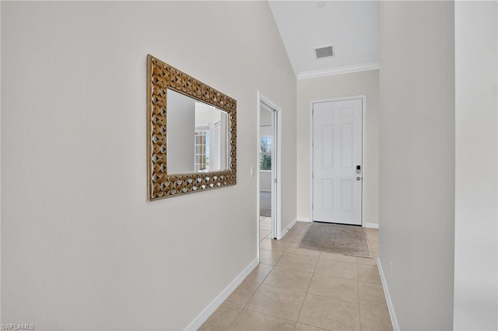 9386 Pocida Court, Unit 202 Naples, FL 34119 - Photo 5 of 38 Corridor with crown molding and light tile patterned flooring