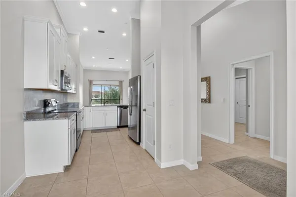 a kitchen with a sink a counter top space stainless steel appliances and cabinets