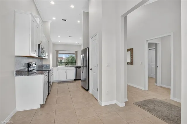 a kitchen with a sink a counter top space stainless steel appliances and cabinets