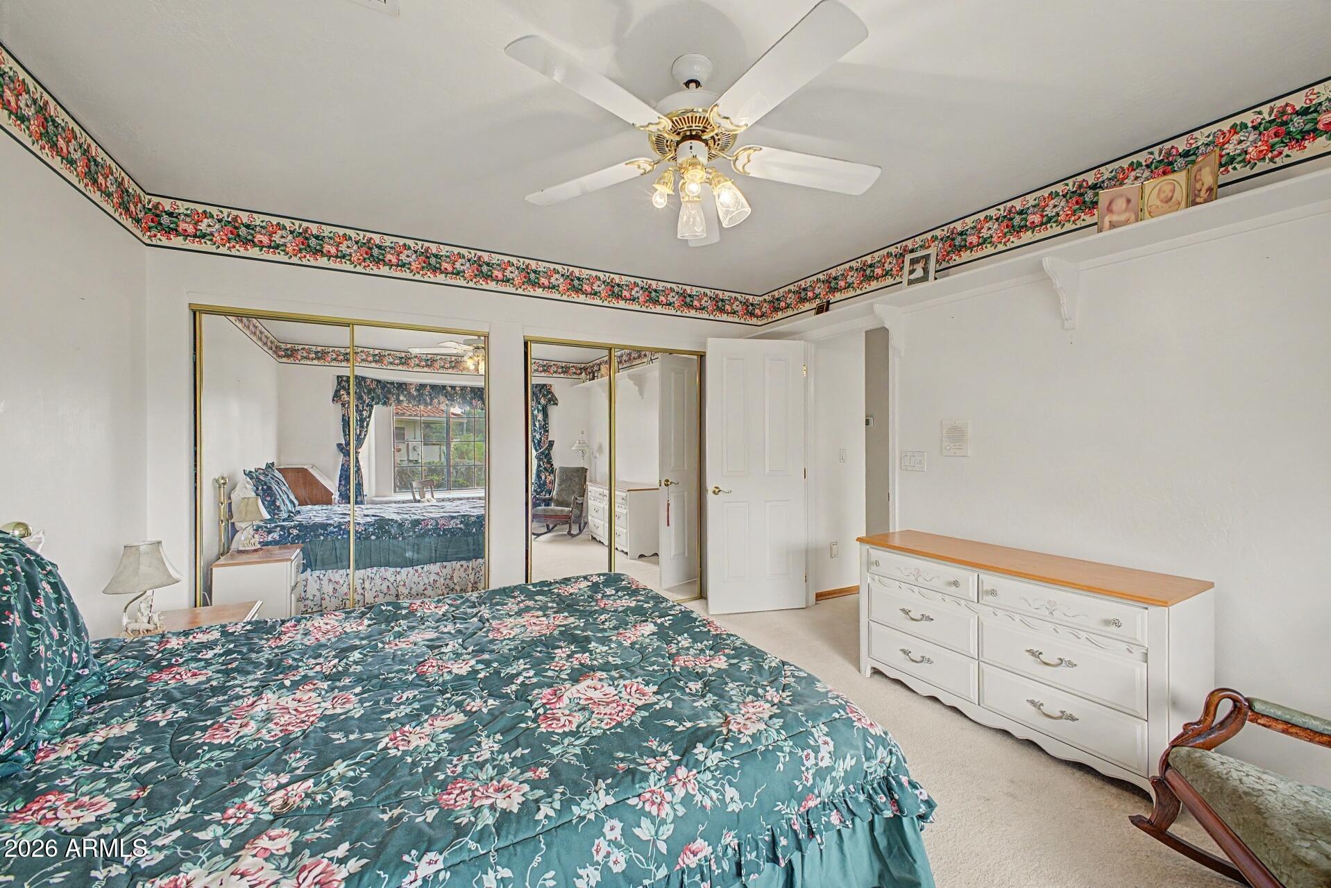 3302 East Draper Circle Mesa, AZ 85213 - Photo 27 of 42 a bedroom with a large bed and a chandelier