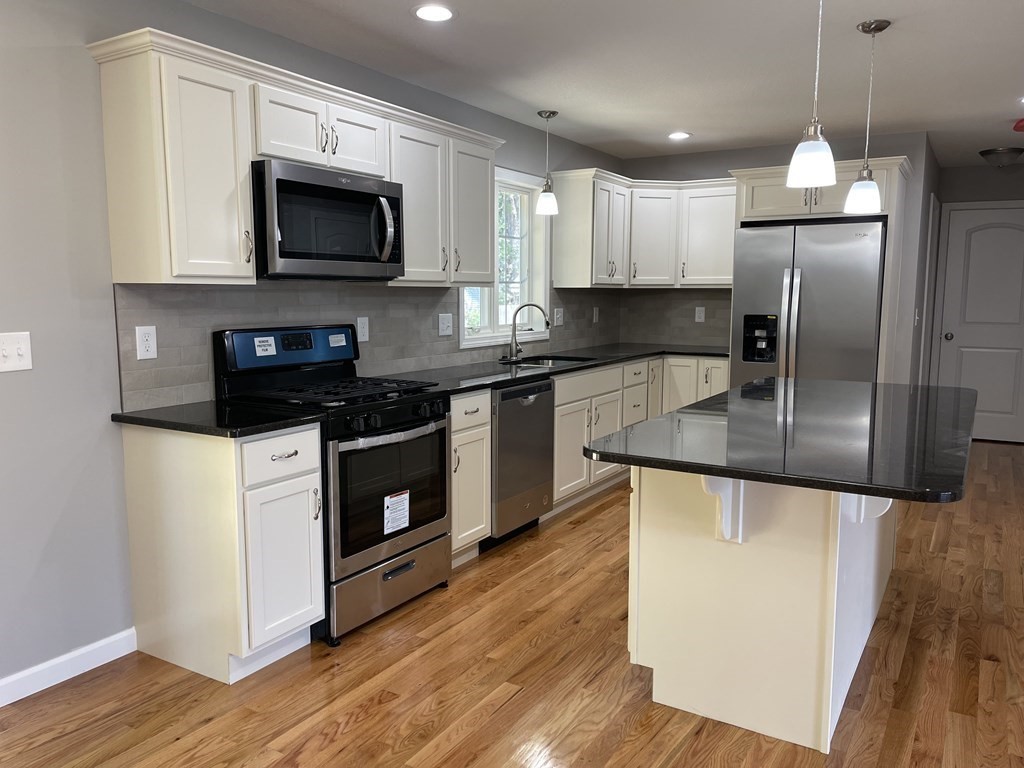 24 Blodgett Street Springfield, MA 01108 - Photo 4 of 26 a kitchen with stainless steel appliances granite countertop a stove a sink and a microwave