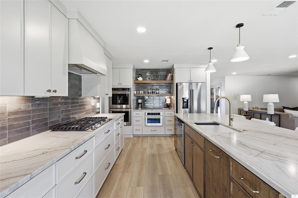 3611 High Drive Grapevine, TX 76051 - Photo 12 of 40 a large kitchen with kitchen island a large counter space a sink appliances and cabinets