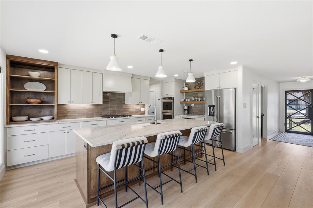 3611 High Drive Grapevine, TX 76051 - Photo 3 of 40 a kitchen with stainless steel appliances a dining table chairs stove and cabinets