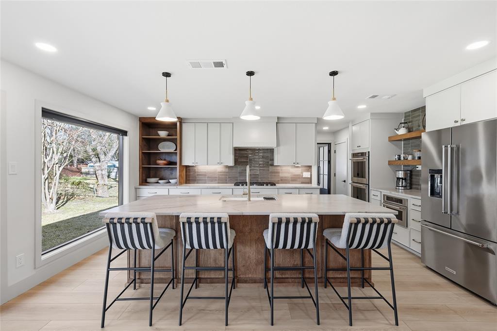 3611 High Drive Grapevine, TX 76051 - Photo 8 of 40 a kitchen with stainless steel appliances kitchen island granite countertop a dining table chairs and a refrigerator