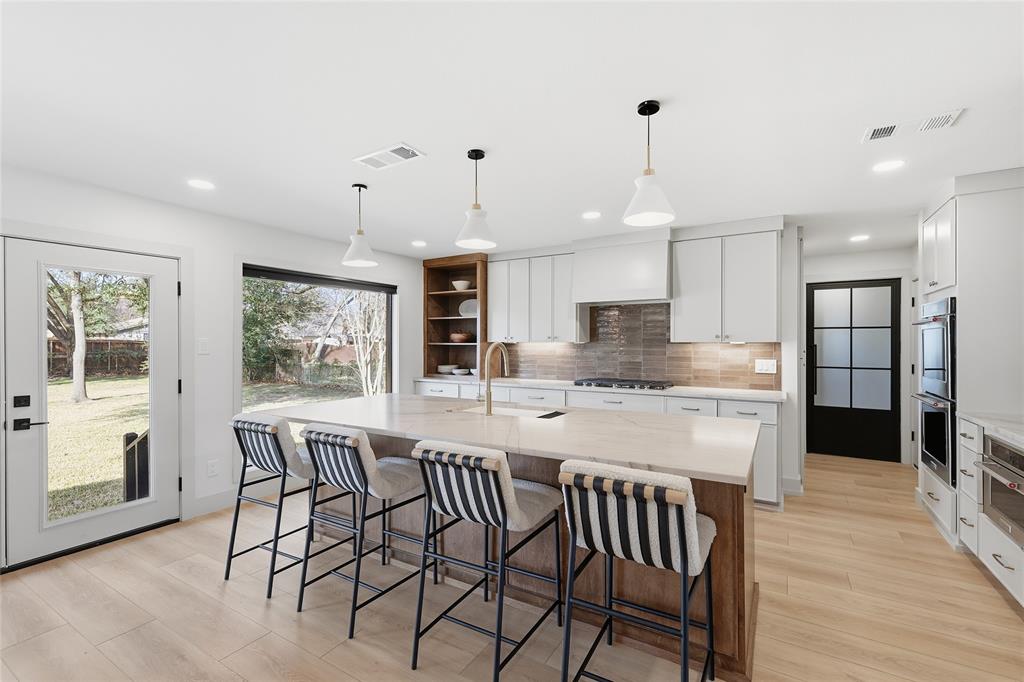 3611 High Drive Grapevine, TX 76051 - Photo 9 of 40 a kitchen with stainless steel appliances granite countertop a kitchen island a stove a table and chairs in it