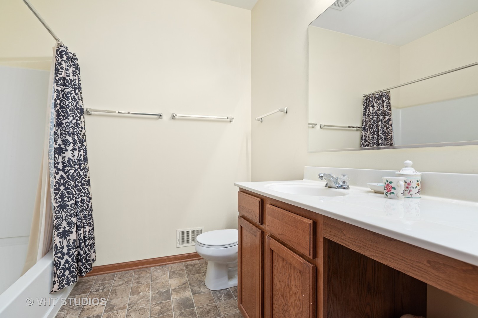 1801 Butterfield Road Woodstock, IL 60098 - Photo 9 of 19 a bathroom with a sink a toilet and shower curtain