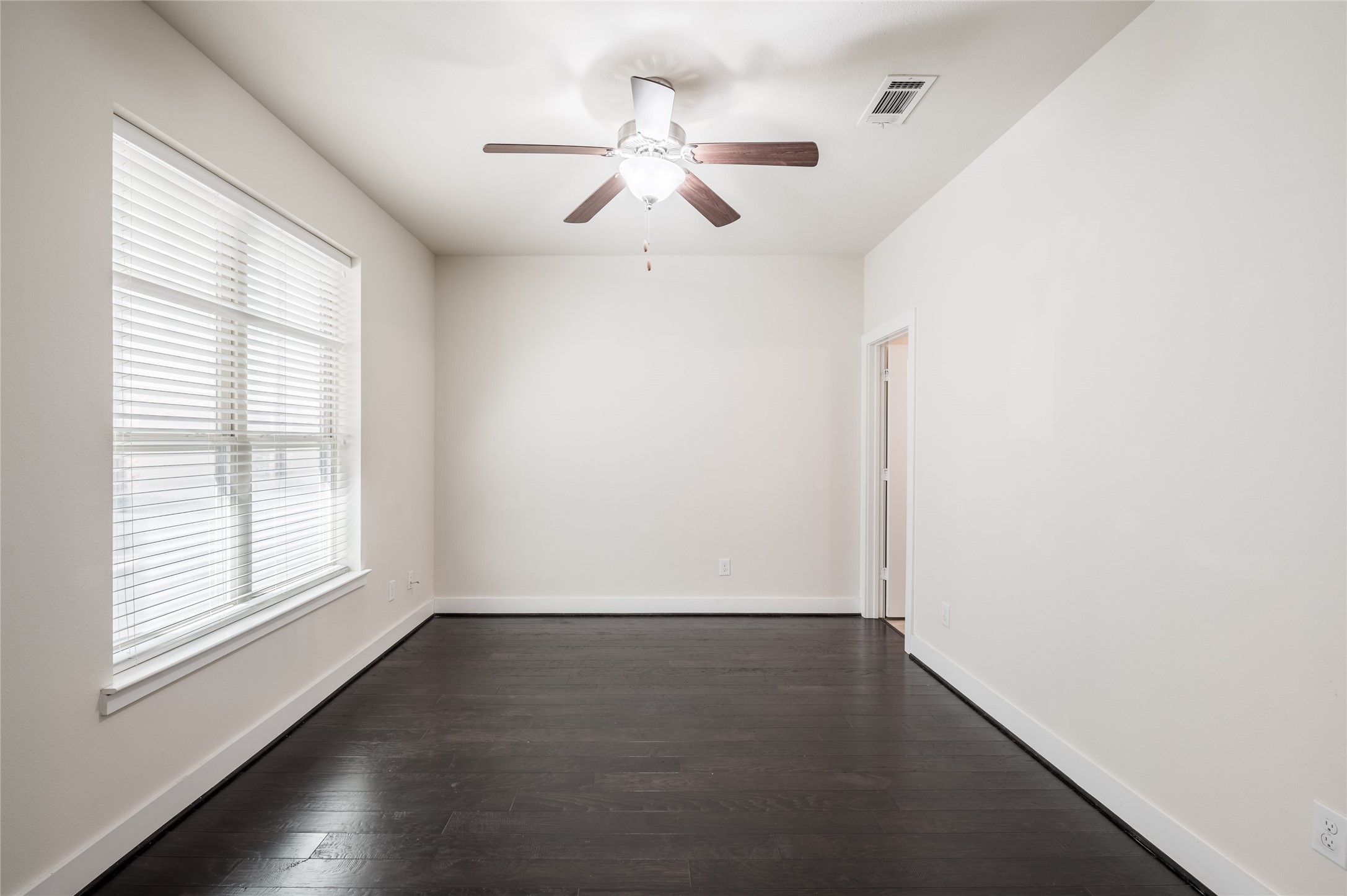 4408 Eli Street, Unit A Houston, TX 77007 - Photo 11 of 22 an empty room with wooden floor chandelier fan and windows