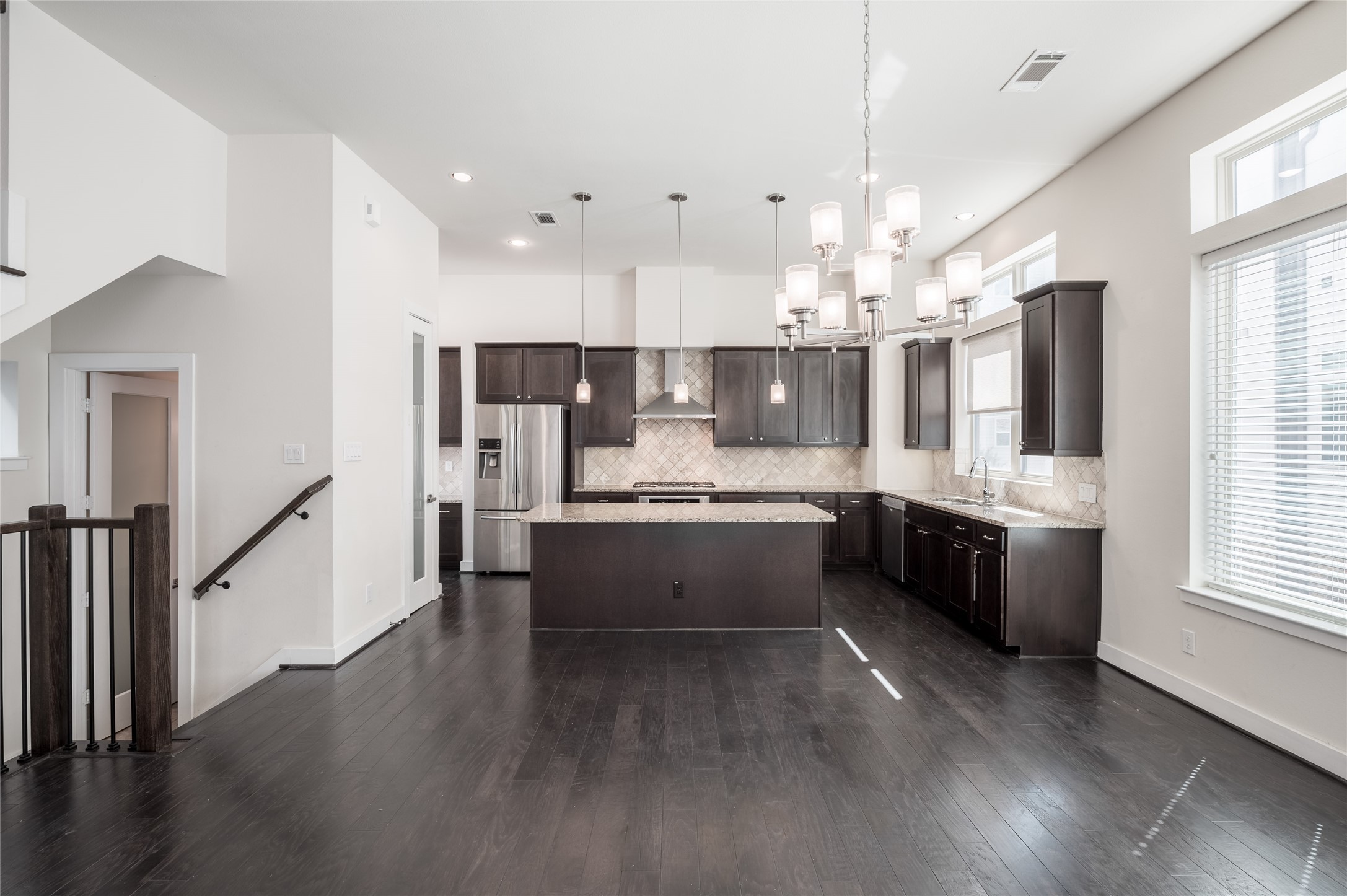 4408 Eli Street, Unit A Houston, TX 77007 - Photo 4 of 22 a large kitchen with a large center island wooden floor stainless steel appliances and windows