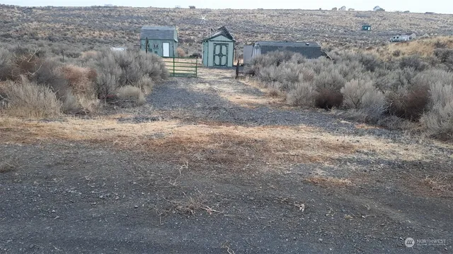 a view of a dry yard with wooden fence
