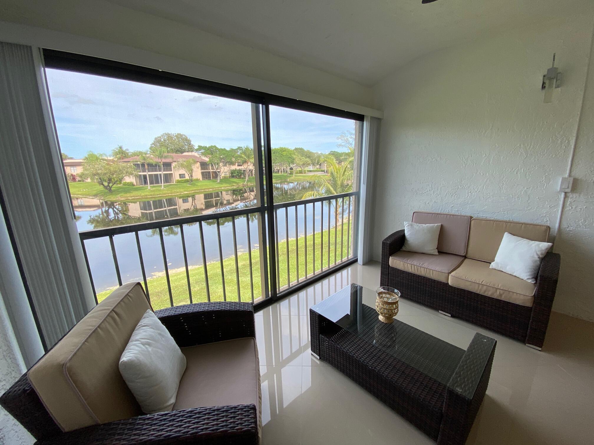9285 Vista Del Lago, Unit 36F Boca Raton, FL 33428 - Photo 12 of 24 a living room with furniture and a floor to ceiling window