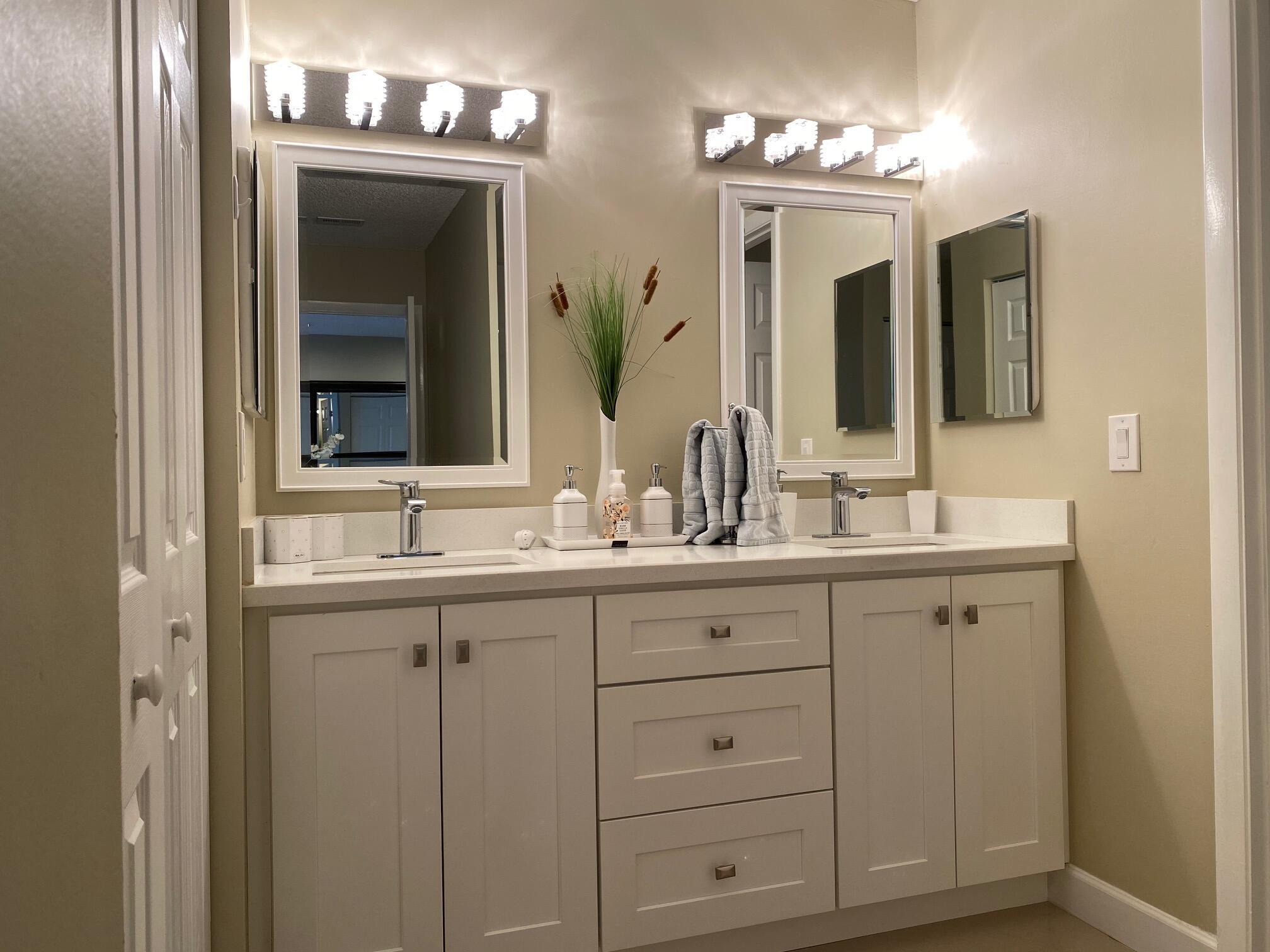 9285 Vista Del Lago, Unit 36F Boca Raton, FL 33428 - Photo 13 of 24 a bathroom with double sink and a mirror