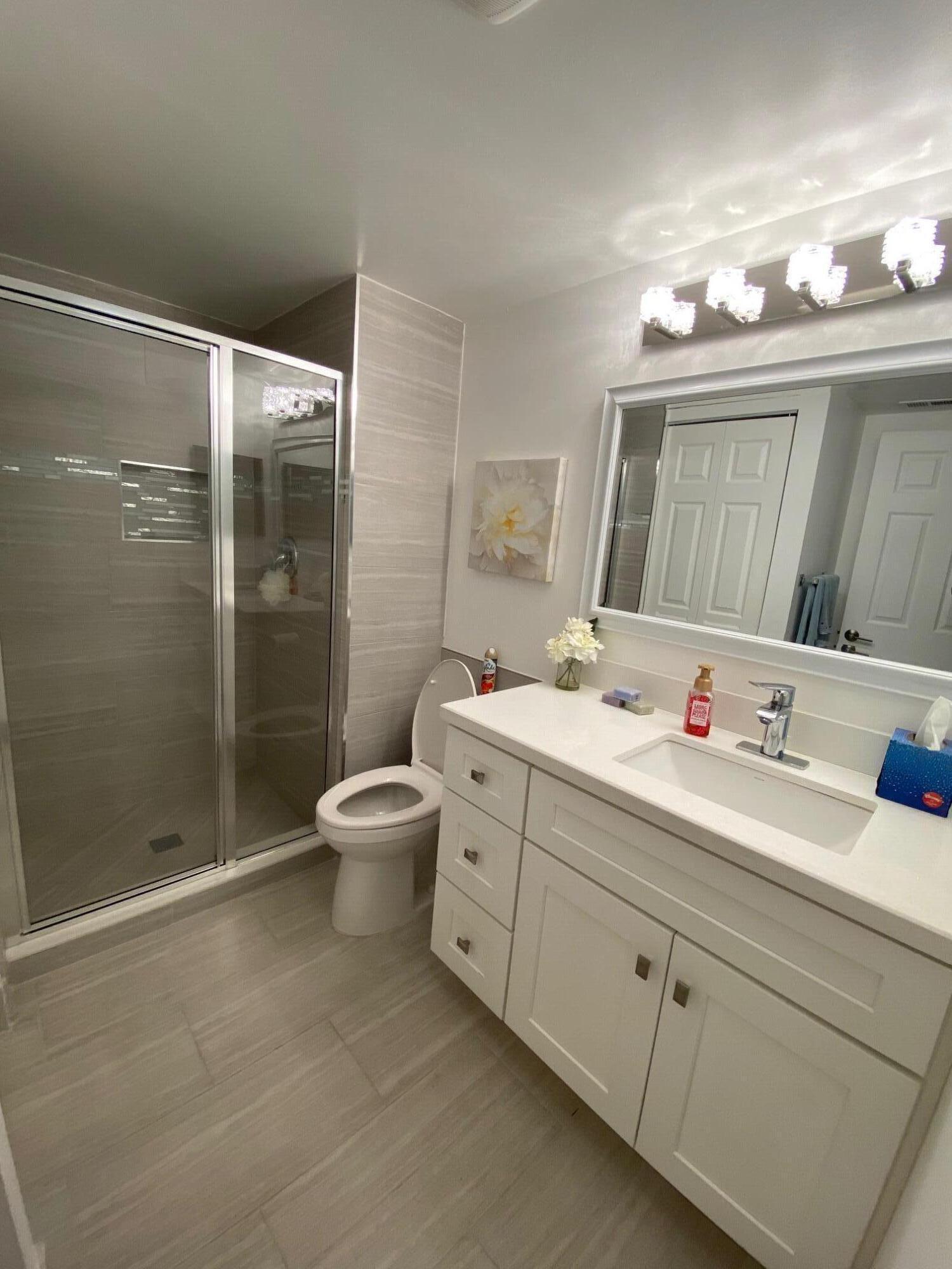 9285 Vista Del Lago, Unit 36F Boca Raton, FL 33428 - Photo 16 of 24 a bathroom with a double vanity sink toilet and shower