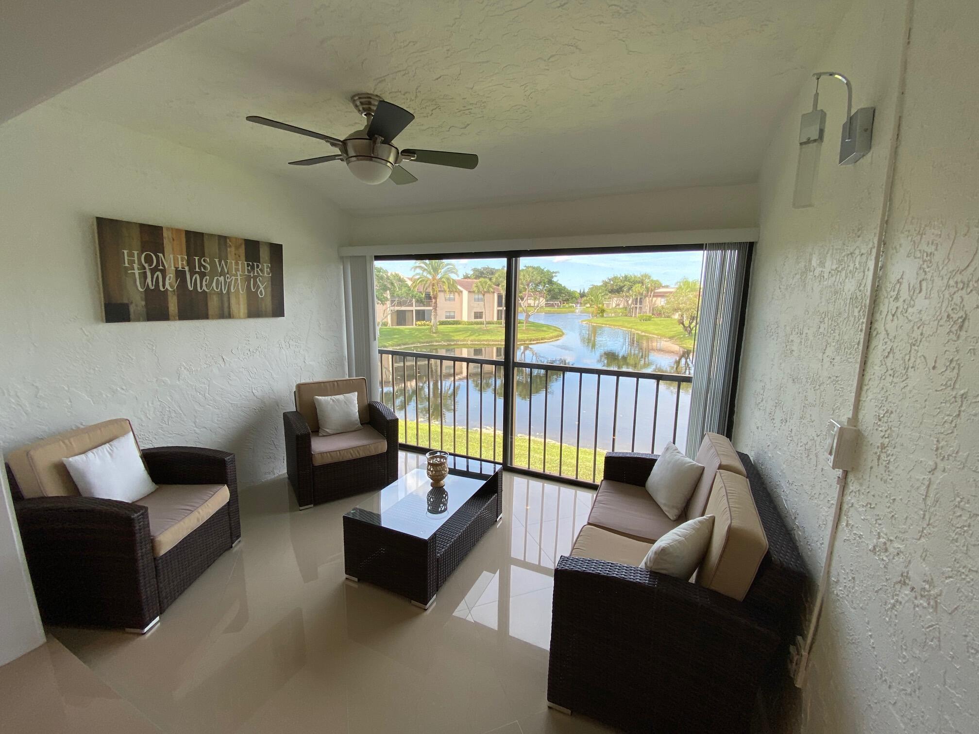 9285 Vista Del Lago, Unit 36F Boca Raton, FL 33428 - Photo 18 of 24 a living room with furniture and a floor to ceiling window