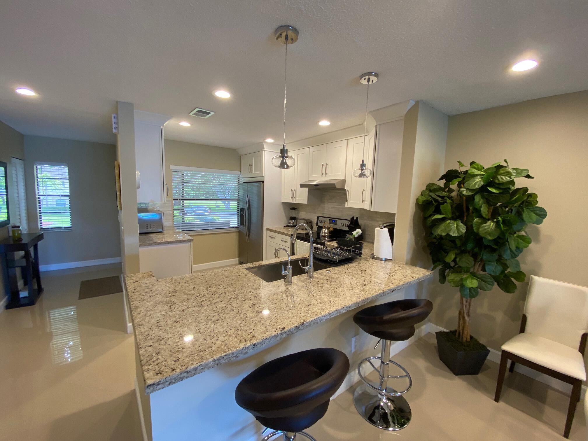 9285 Vista Del Lago, Unit 36F Boca Raton, FL 33428 - Photo 5 of 24 a kitchen with a sink appliances and living room