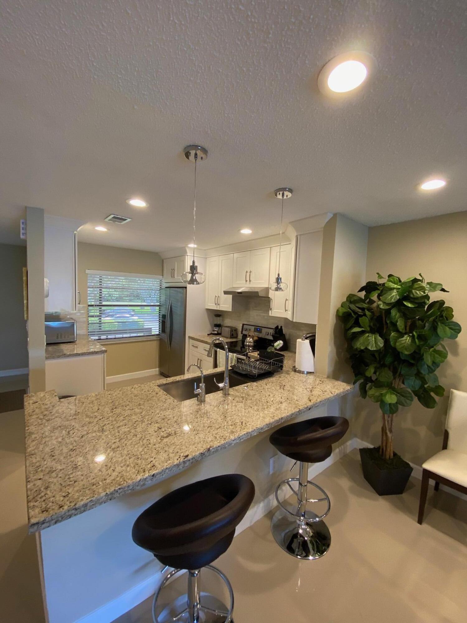 9285 Vista Del Lago, Unit 36F Boca Raton, FL 33428 - Photo 7 of 24 a kitchen with sink and lots of chairs