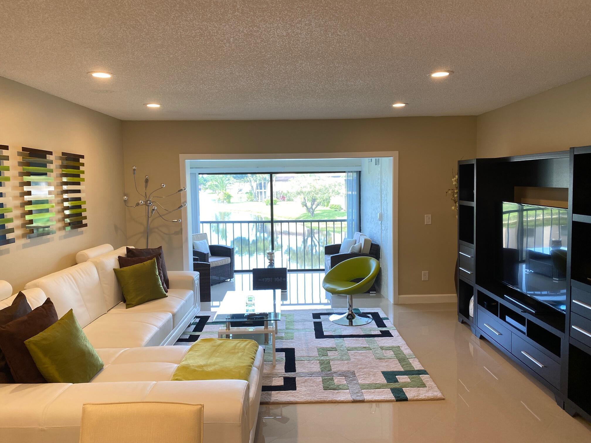 9285 Vista Del Lago, Unit 36F Boca Raton, FL 33428 - Photo 8 of 24 a living room with furniture and a flat screen tv