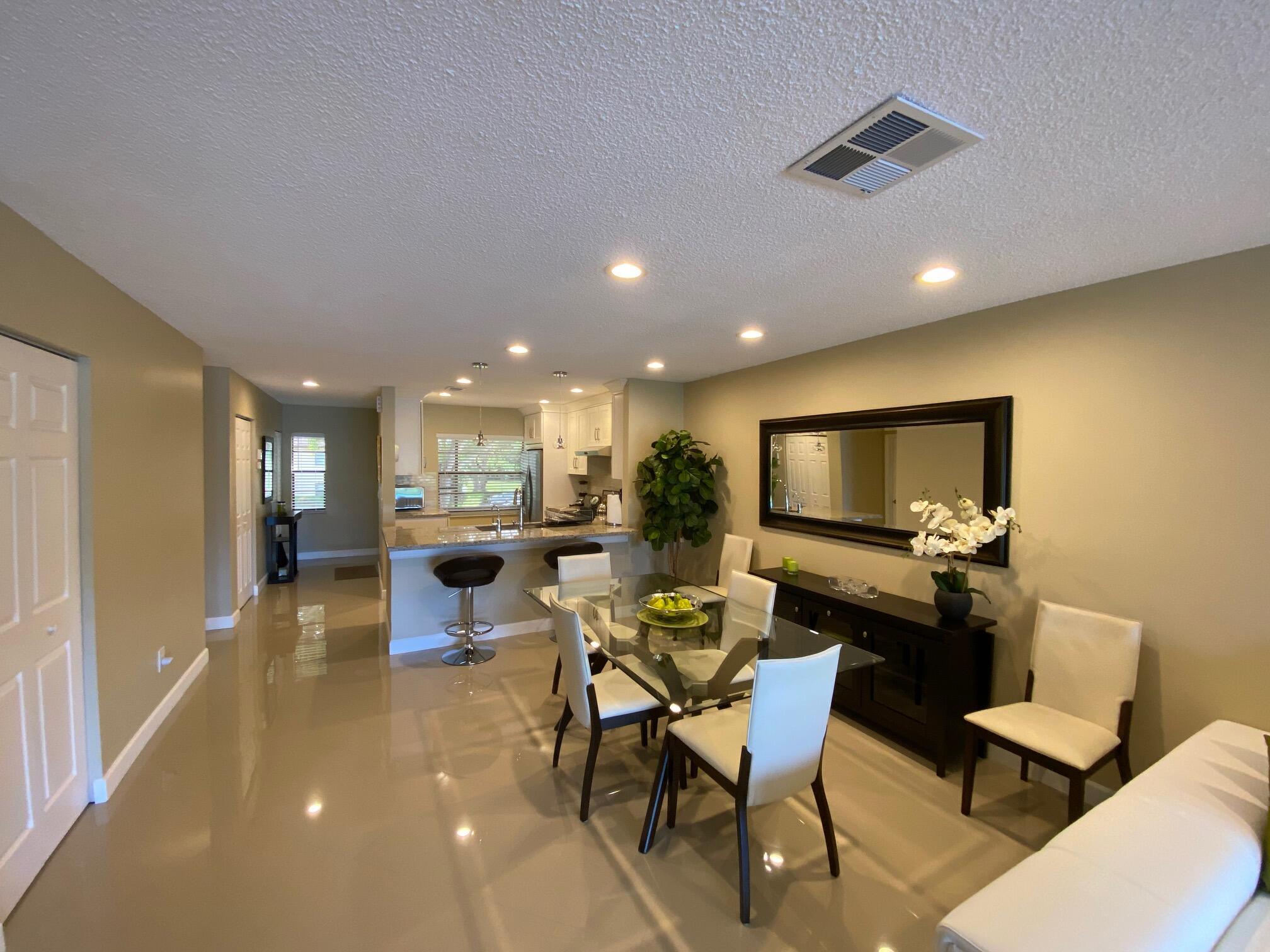 9285 Vista Del Lago, Unit 36F Boca Raton, FL 33428 - Photo 9 of 24 a living room with furniture and a flat screen tv