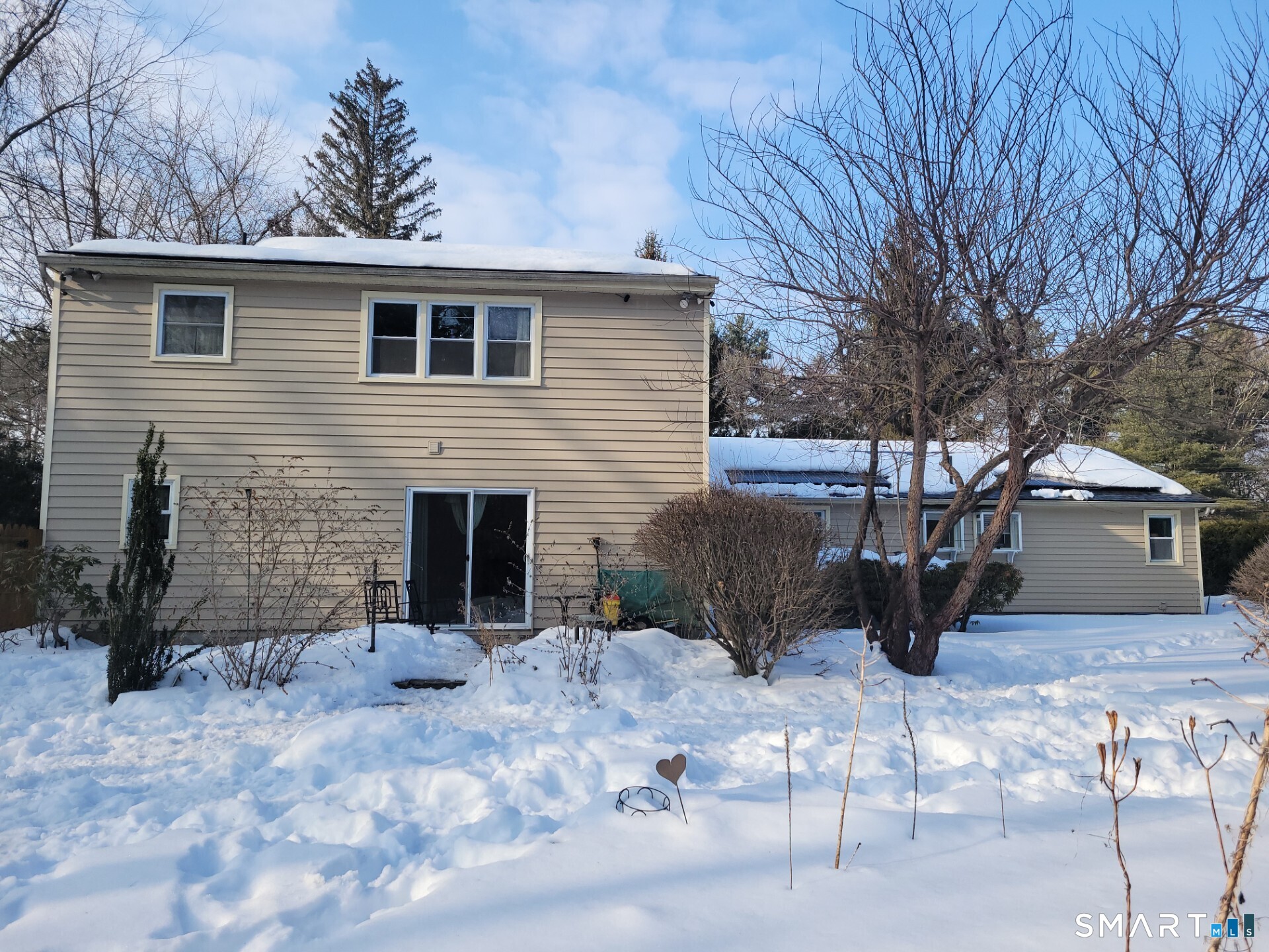 a view of a backyard that has a table and chairs with wooden fence