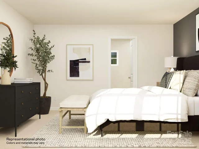 a bedroom with a bed and a lamp on dresser