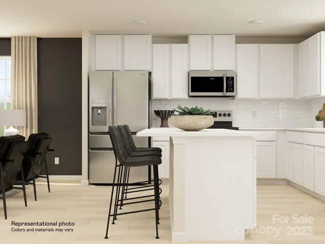 a kitchen with stainless steel appliances white cabinets and a refrigerator