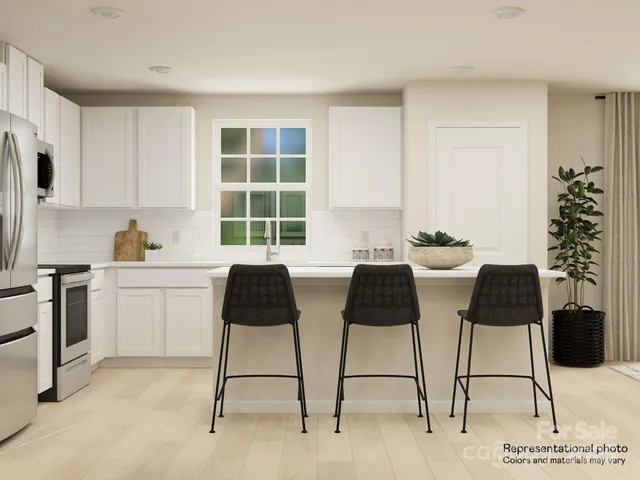 a kitchen with stainless steel appliances kitchen island granite countertop a table chair and a cabinets