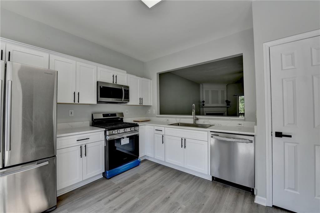 3977 Howell Park Road Duluth, GA 30096 - Photo 15 of 25 a kitchen with granite countertop white cabinets and stainless steel appliances