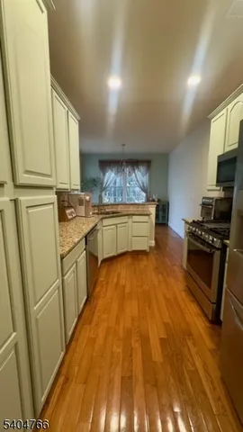 a kitchen with wooden floors and appliances