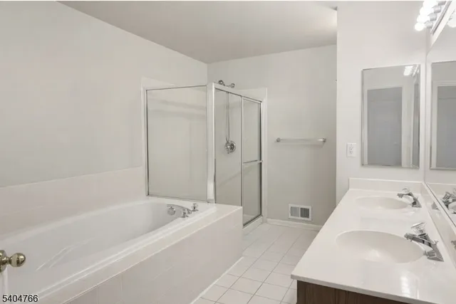 a bathroom with a tub sink and mirror