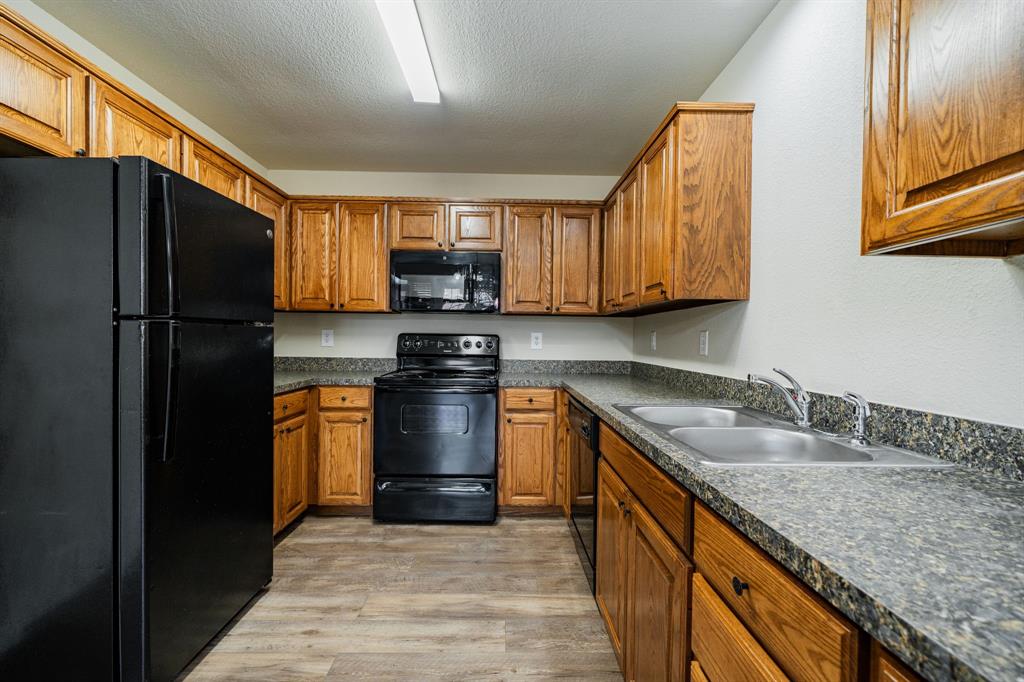 26 Duplex Portfolio Commerce, TX 75428 - Photo 18 of 39 a kitchen with stainless steel appliances granite countertop a sink stove and refrigerator