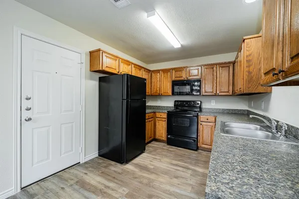 a kitchen with granite countertop a refrigerator stove and oven