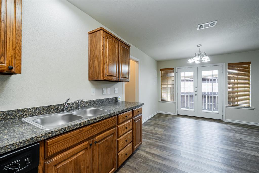 26 Duplex Portfolio Commerce, TX 75428 - Photo 20 of 39 a kitchen with stainless steel appliances granite countertop a sink a stove cabinets and wooden floor