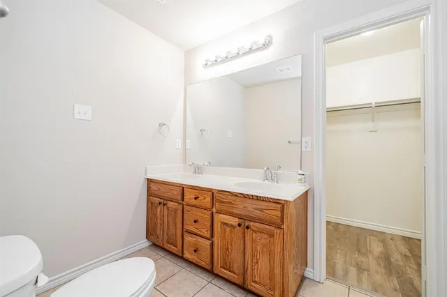 a spacious bathroom with a toilet a sink and a mirror