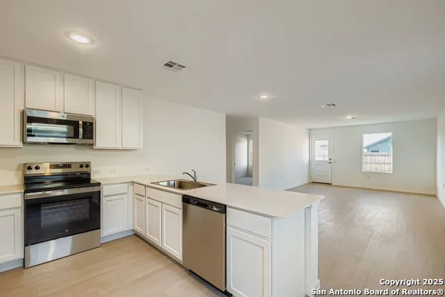 a kitchen that has a sink and a stove top oven