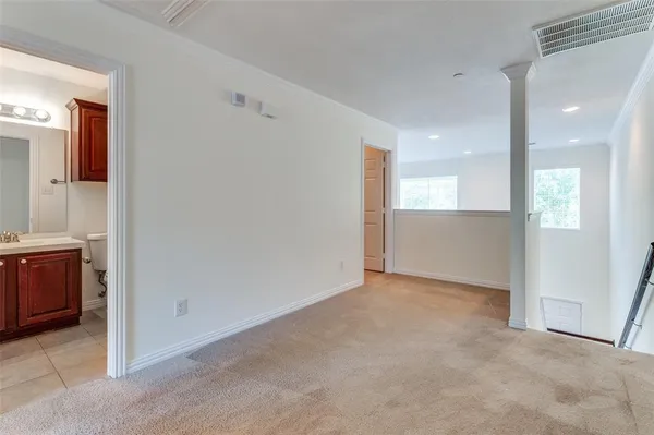 a view of an empty room and a kitchen