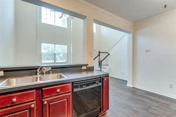 a kitchen with stainless steel appliances granite countertop a sink and wooden floors