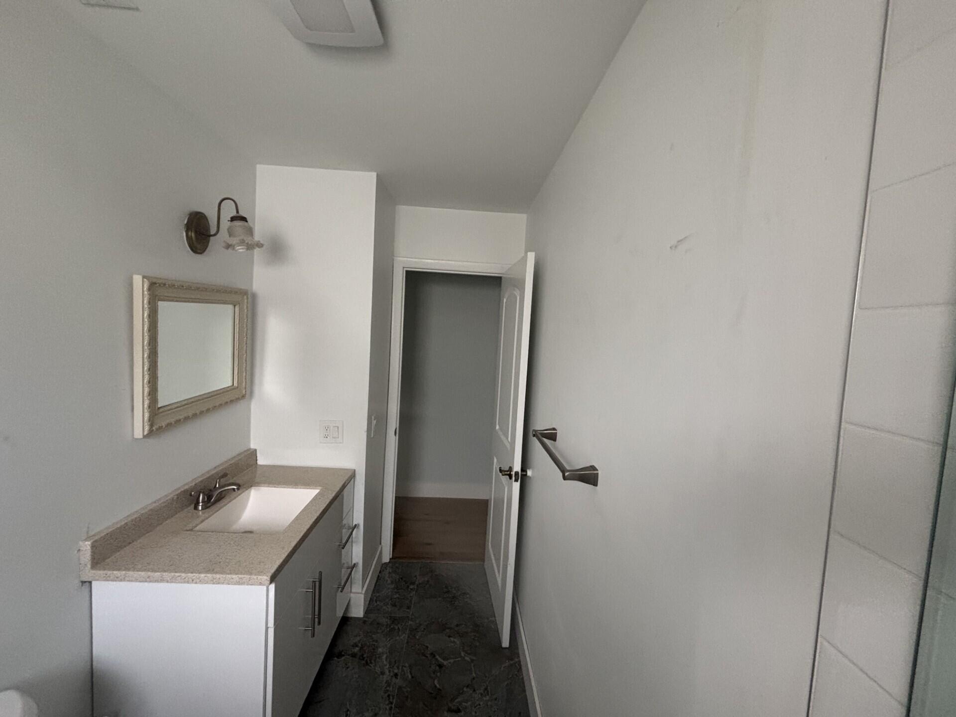 1160 East 12th Street Stuart, FL 34996 - Photo 13 of 25 a bathroom with a granite countertop sink