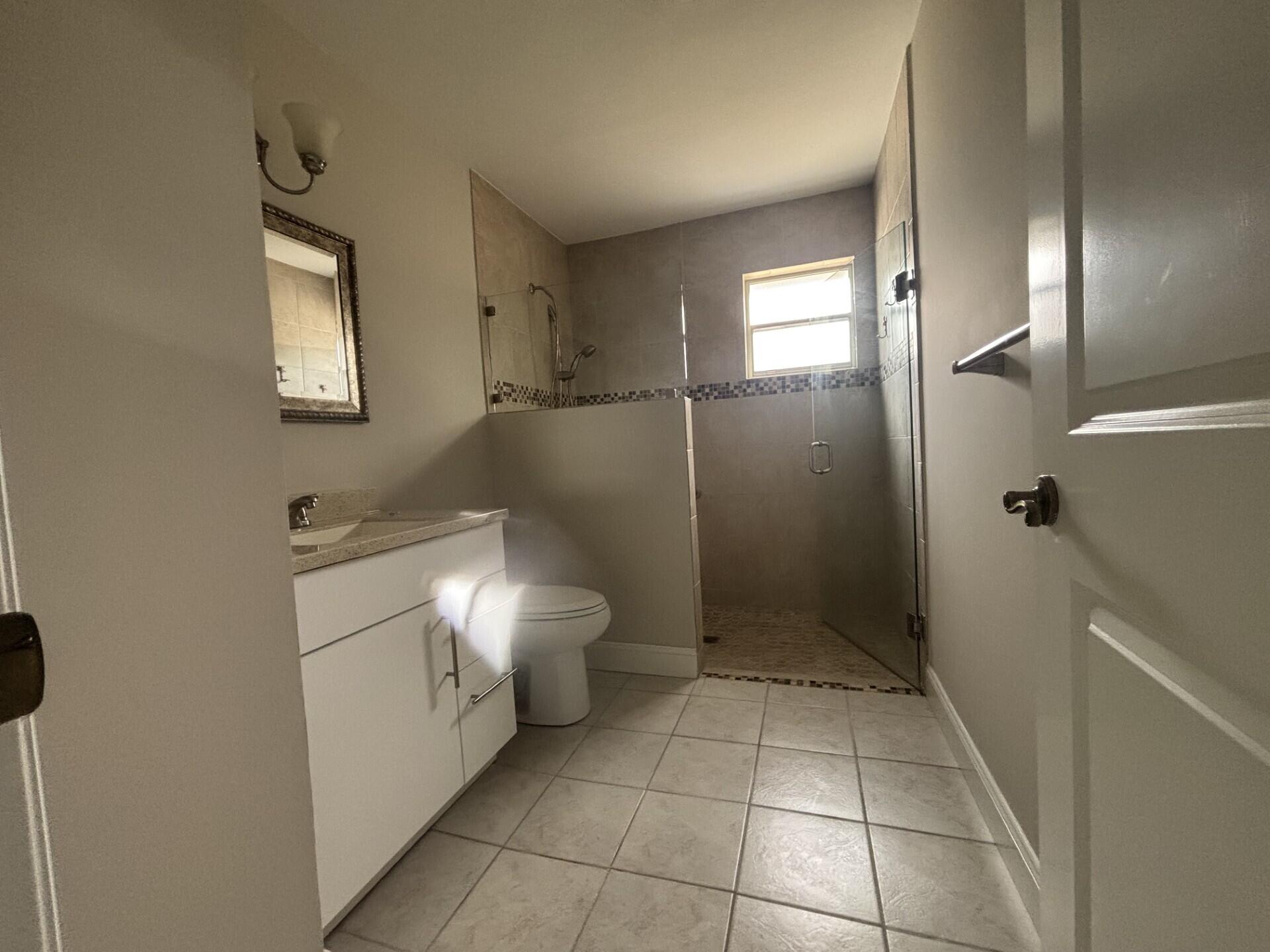 1160 East 12th Street Stuart, FL 34996 - Photo 17 of 25 a bathroom with a sink a toilet and shower