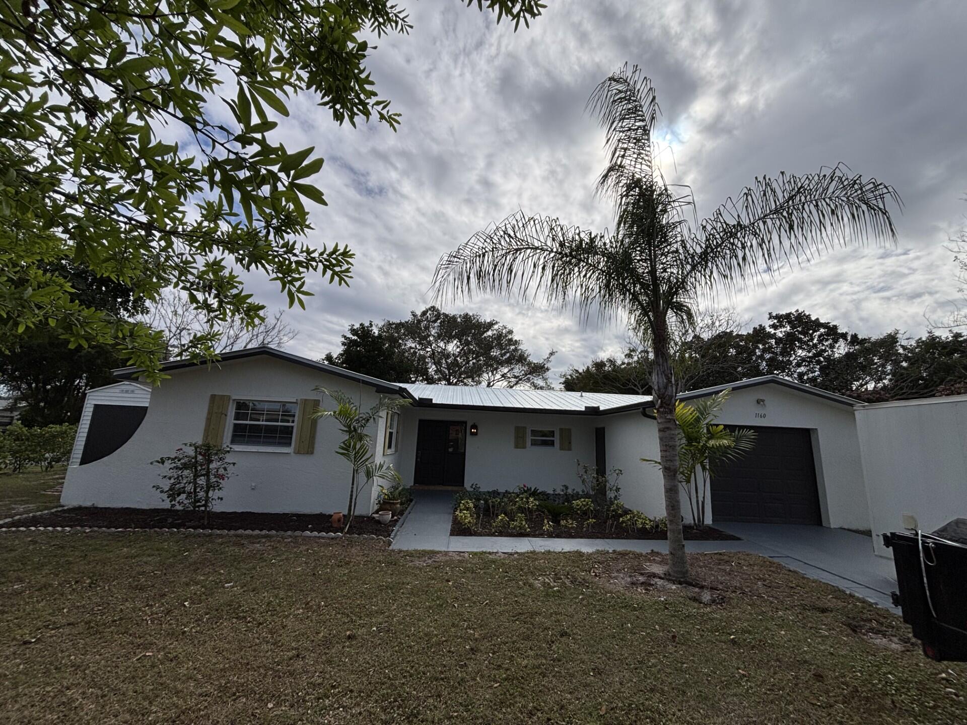 1160 East 12th Street Stuart, FL 34996 - Photo 2 of 25 a front view of a house with garden