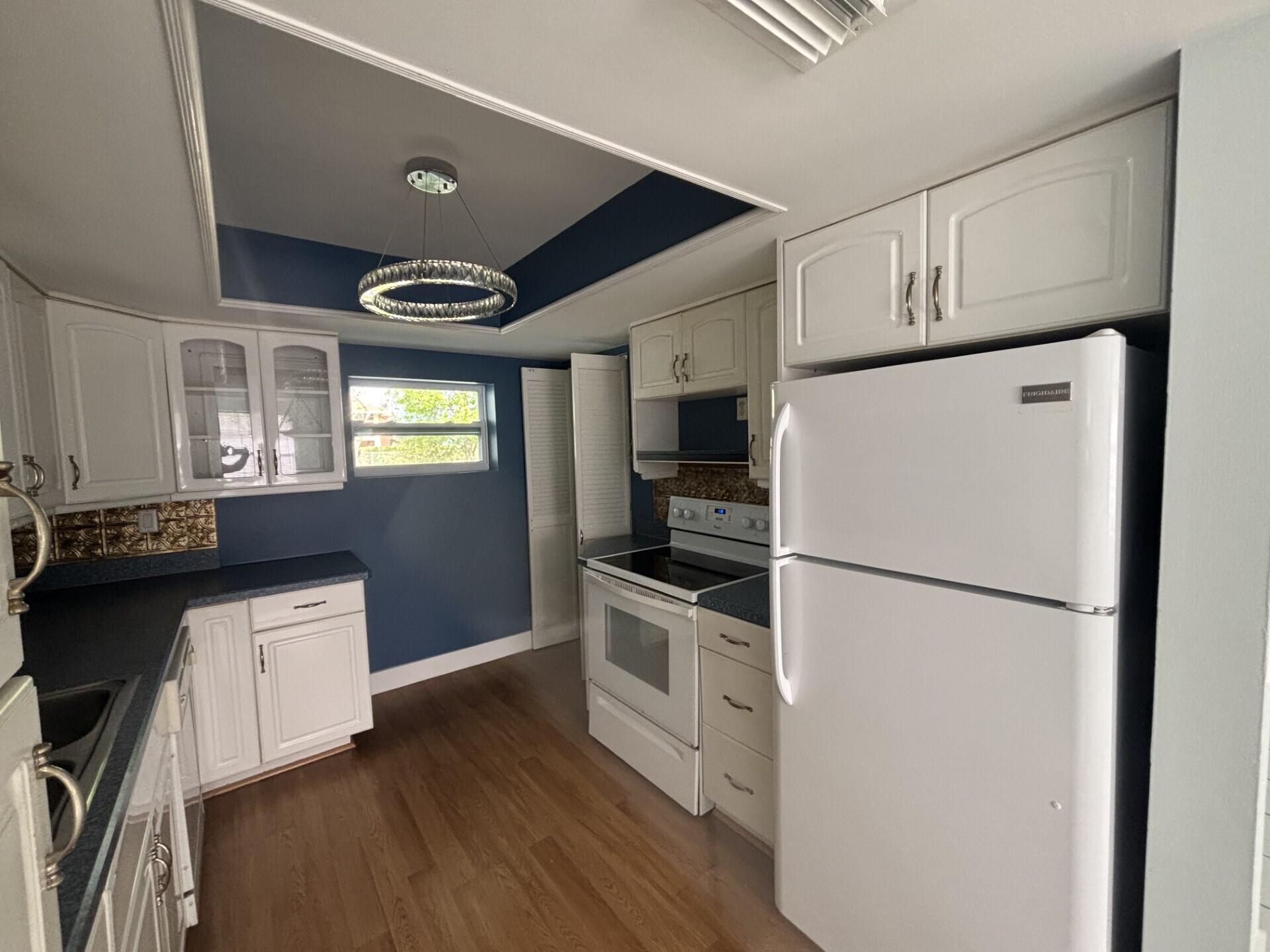 1160 East 12th Street Stuart, FL 34996 - Photo 5 of 25 a kitchen with stainless steel appliances a refrigerator a stove a sink and white cabinets