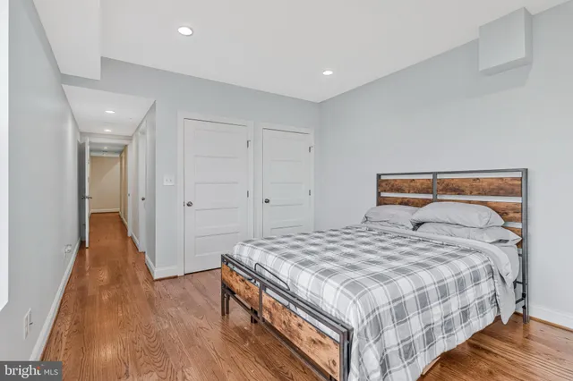 a bedroom with a bed and wooden floor