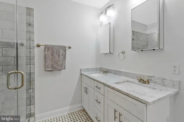 a bathroom with a granite countertop sink a mirror a vanity and shower