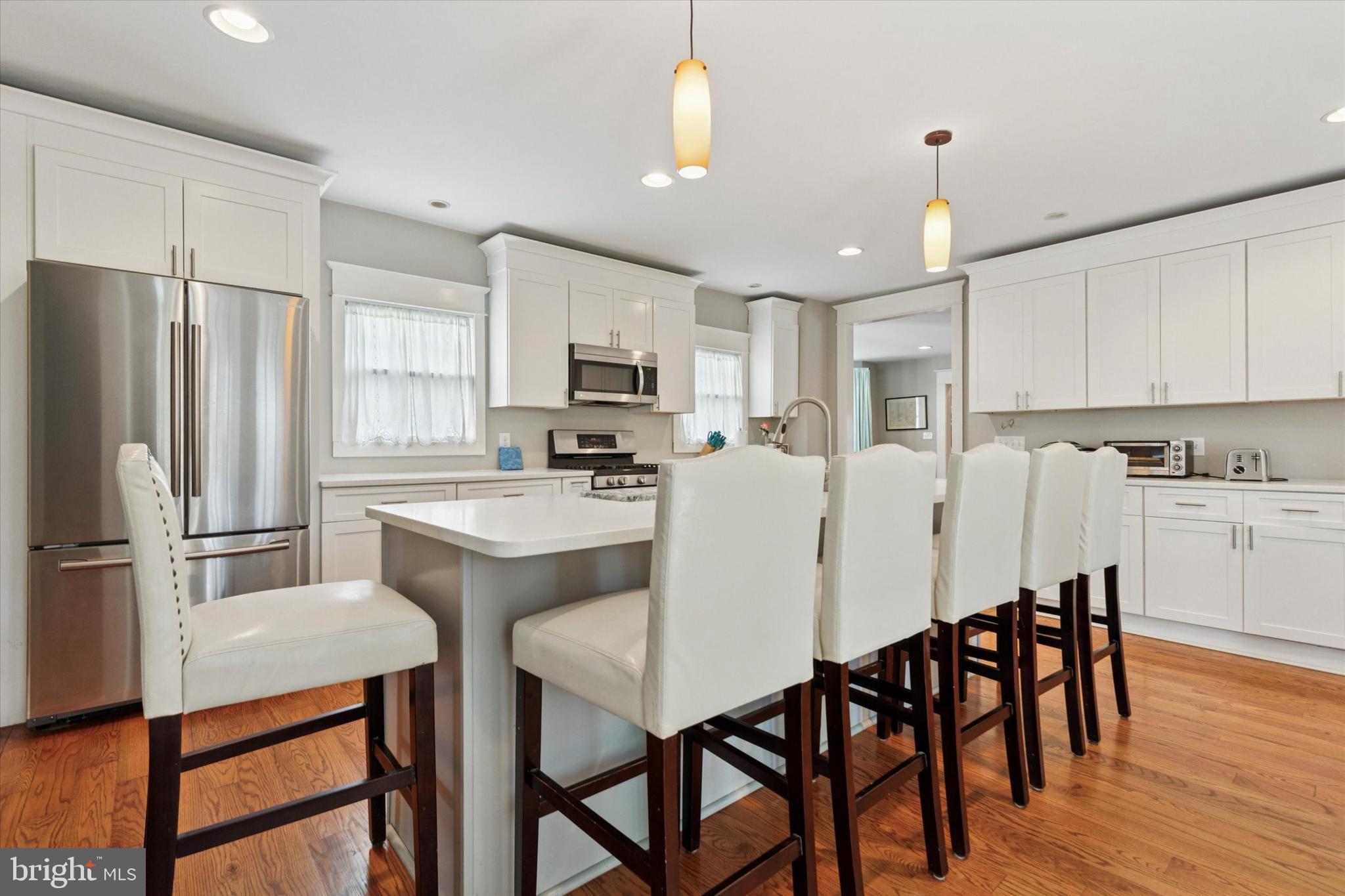 140 North Rolling Road Springfield, PA 19064 - Photo 12 of 34 a kitchen with stainless steel appliances a table chairs refrigerator microwave and cabinets